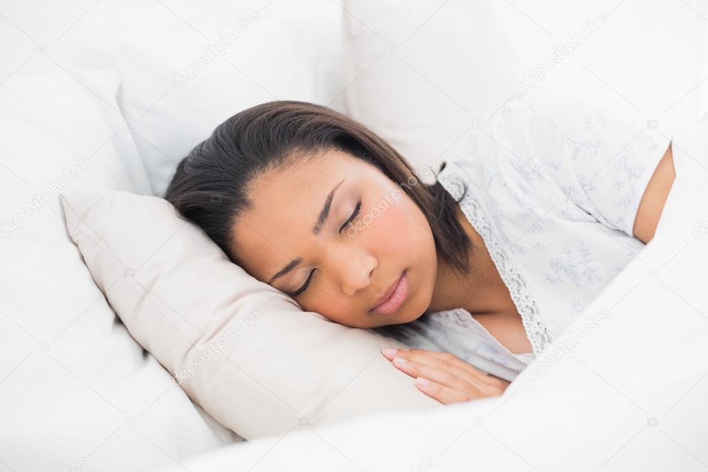 Peaceful young model sleeping in her bed