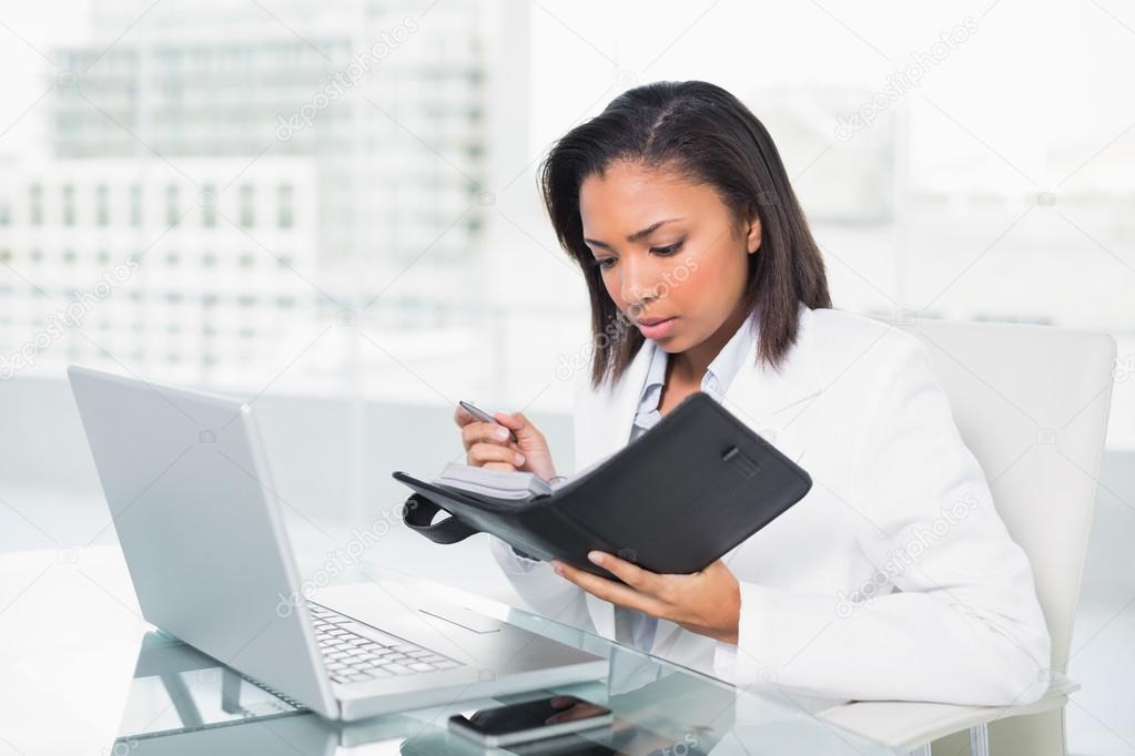 Anxious young businesswoman filling her schedule