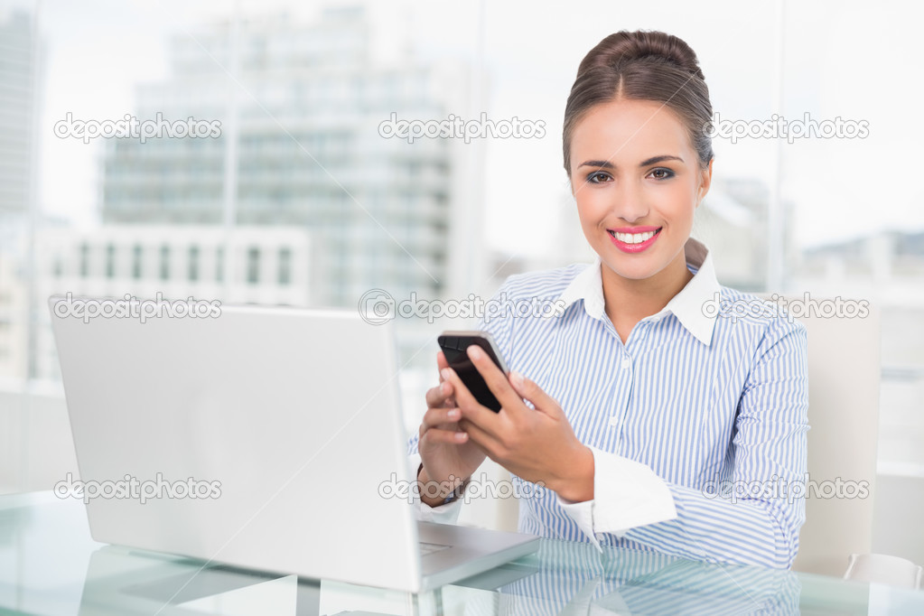 Smiling businesswoman holding smartphone