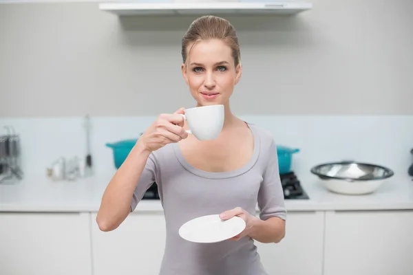 Feliz hermosa modelo mirando a la cámara sosteniendo taza —  Fotos de Stock