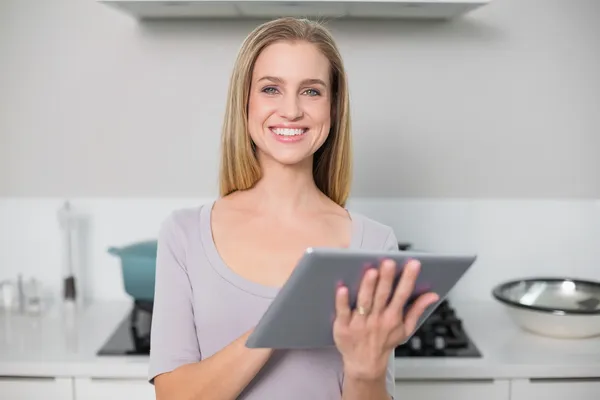 Lächelndes Prachtmodell mit Tablet vor der Kamera — Stockfoto