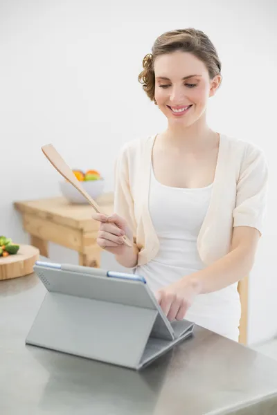 Lachende brunette vrouw permanent in haar keuken — Stockfoto