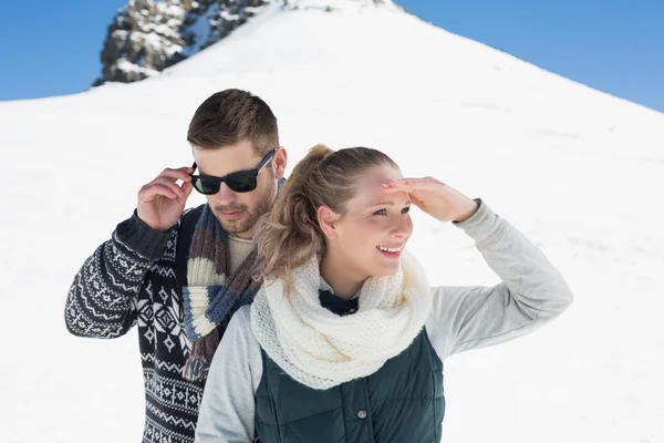Pareja en ropa de abrigo frente a la colina nevada —  Fotos de Stock