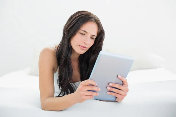 Mulher casual usando tablet PC na cama — Fotografia de Stock