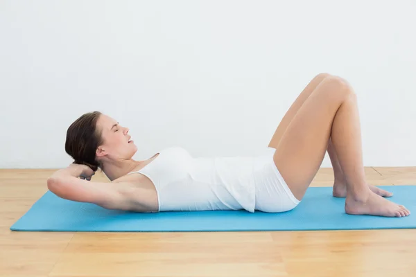 Zijaanzicht van de vrouw oefening op mat — Stockfoto