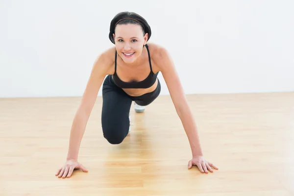 Leende sportiga kvinna göra push ups i fitness-studio — Stockfoto