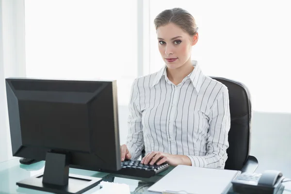 Concentrada linda mujer de negocios trabajando en su computadora mientras está sentada —  Fotos de Stock