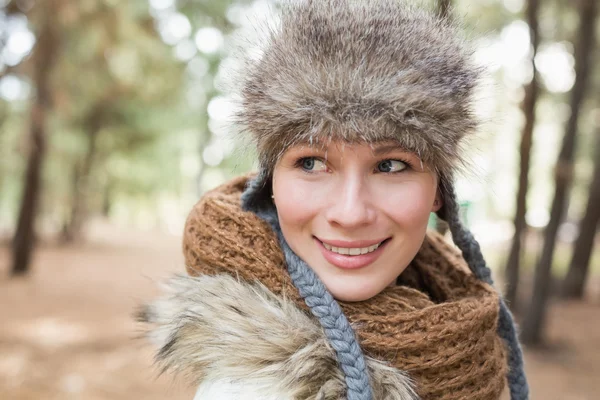 Kvinna i pälsmössa med ull halsduk i skogen — Stockfoto