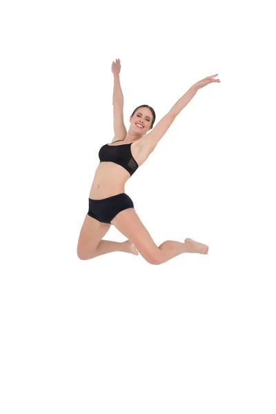 Sonriente mujer deportiva saltando sobre fondo blanco —  Fotos de Stock