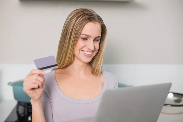 Modelo lindo alegre segurando laptop e cartão de crédito — Fotografia de Stock