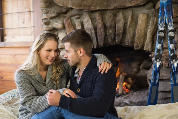 Romantic couple in front of lit fireplace — Stock Photo, Image