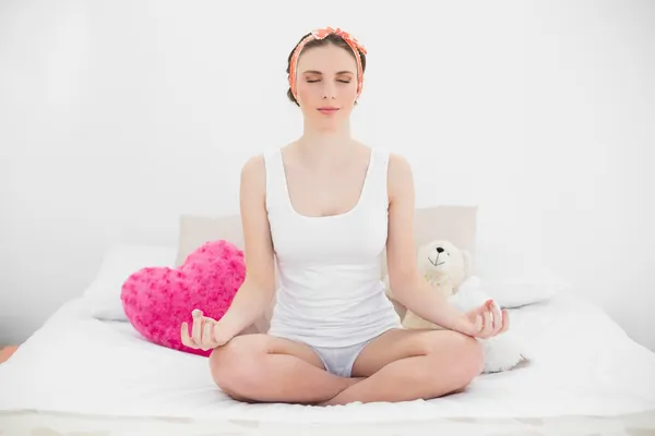 Meditierende junge Frau sitzt auf ihrem Bett — Stockfoto