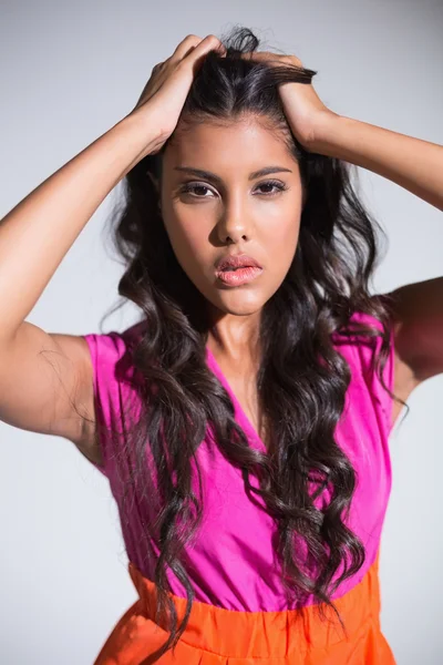 Seductive attractive brunette posing for camera ruffling hair — Stock Photo, Image