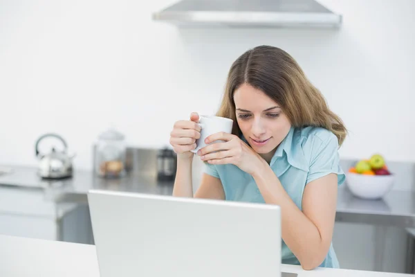 Schattige rustige vrouw die met haar notitieblok een kopje bedrijf werkt — Stockfoto