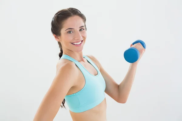 Side view portrait of a smiling woman with dumbbell — Stock Photo, Image