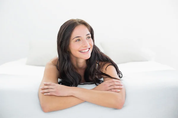 Mujer sonriente mirando en la cama —  Fotos de Stock