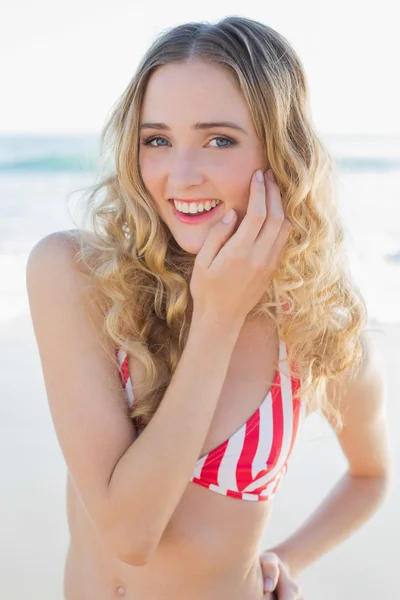 Fröhliche junge Frau posiert im roten Bikini am Strand — Stockfoto