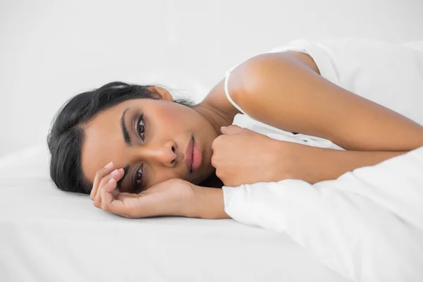 Fatigué belle femme couchée sous la couverture sur son lit — Photo