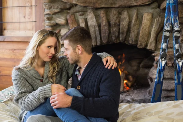 Young couple in front of lit fireplace — Stock Photo, Image