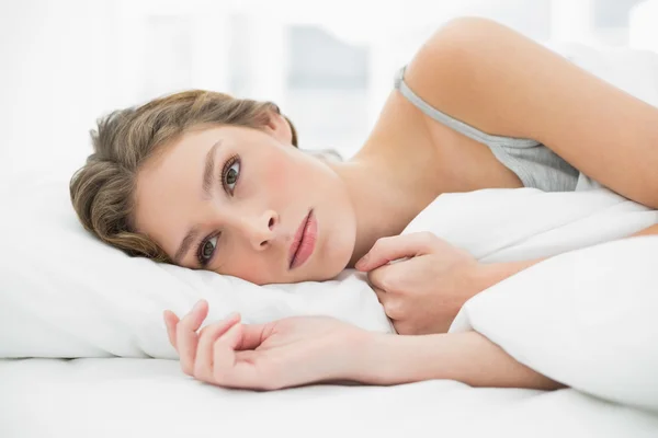 Femme calme couchée sous la couverture sur son lit blanc — Photo