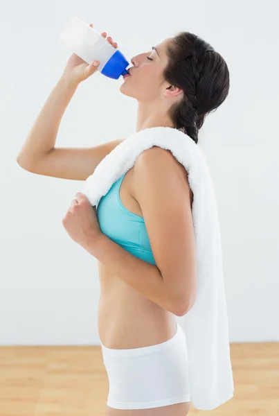 Fit young woman drinking water at fitness studio — Stock Photo, Image