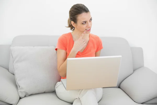 Aantrekkelijke doordachte vrouw met behulp van haar notitieblok zittend op de Bank — Stockfoto