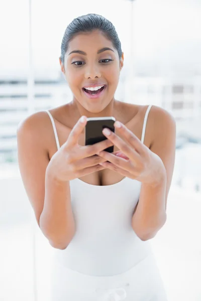 Excited toned brunette holding mobile phone — Stock Photo, Image