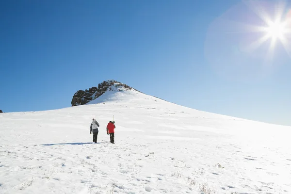 Skiers walking on snow on a sunny day — Stock Photo, Image