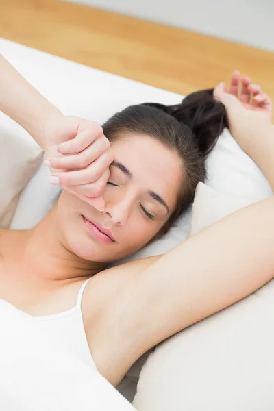 Schöne Frau streckt Arme im Bett aus — Stockfoto