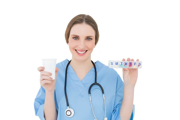 Jovem médica segurando um copo de plástico e medicina — Fotografia de Stock