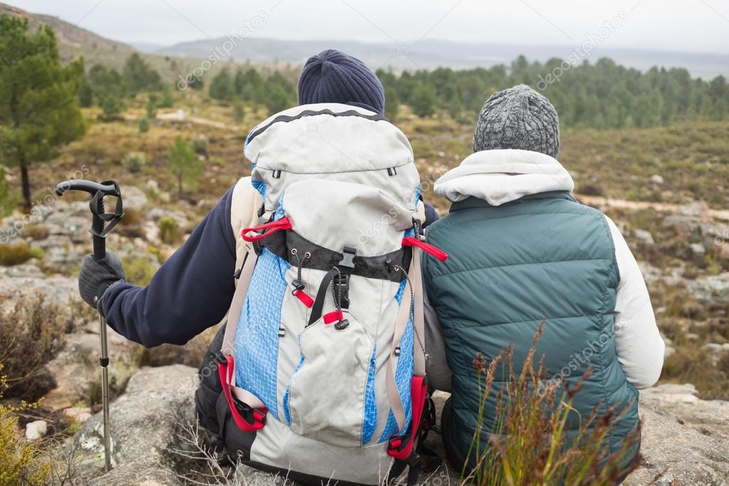 Couple with backpack and trekking pole on a hike