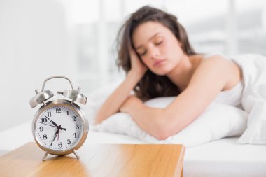 çalar saat ön planda olan Sleepy kadın