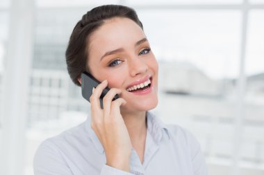 핸드폰을 사용 하 여 밝고 우아한 젊은 사업가