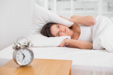 yastık yatak ve çalar saat tablo kulaklarıyla kapsayan kadın