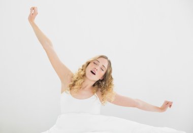 oldukça yorgun sarışın yatak esneme oturan