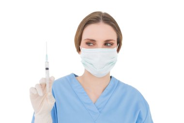 genç esmer kadın doktor bir şırınga tutarak