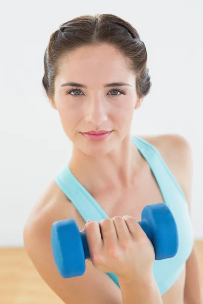 Jonge vrouw met dumbbell op fitness-studio — Stockfoto