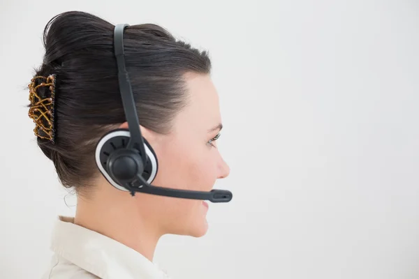 Side view of a beautiful businesswoman using headset — Stock Photo, Image