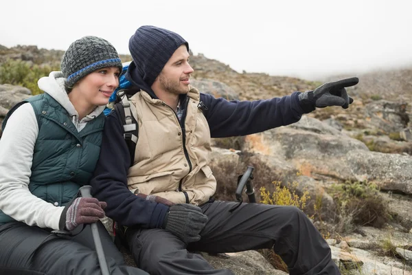 Paar auf einer Wanderung mit Trekkingstöcken am Felsen — Stockfoto