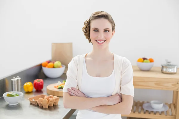 Schöne junge Frau posiert in ihrer Küche mit verschränkten Armen — Stockfoto