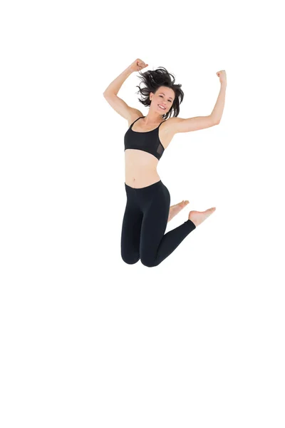 Sporty young woman jumping over white background — Stock Photo, Image