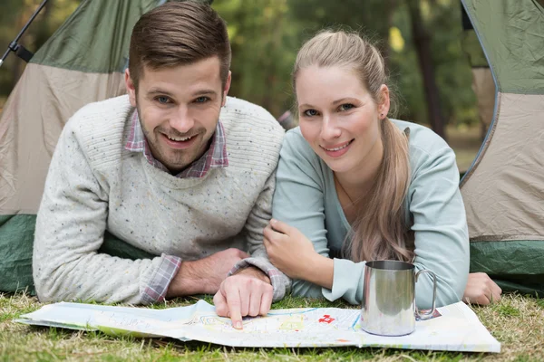 地图在帐篷里微笑着年轻夫妇的肖像 — 图库照片