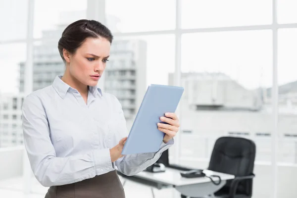 Serious businesswoman using table PC in office — Stock Photo, Image