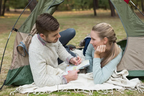 情侣躺在帐篷里的一张地图 — 图库照片