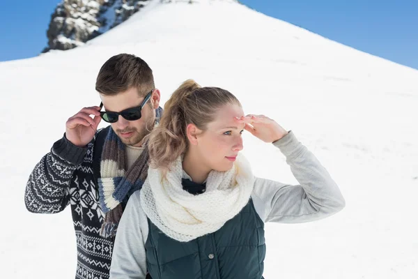 Couple en vêtements chauds contre colline enneigée — Photo