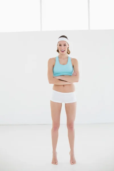 Femme sportive posant en vêtements de sport debout dans la salle de sport — Photo