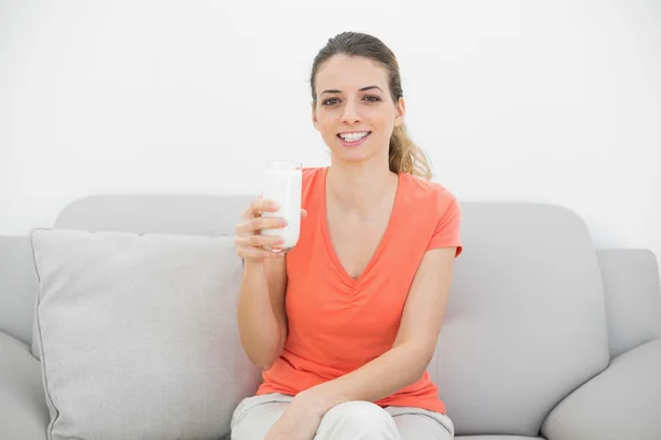 Mujer morena alegre sosteniendo un vaso de leche sonriendo felizmente —  Fotos de Stock