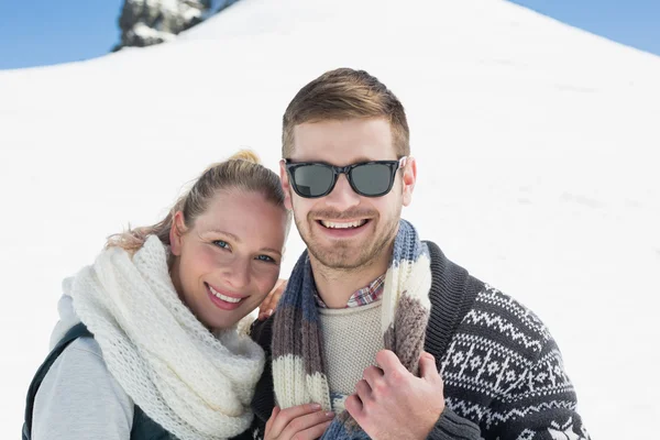 Smiling couple in front of snowed hill — Stock Photo, Image