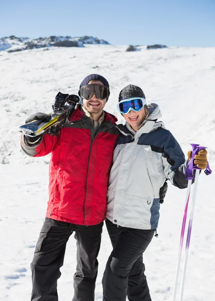 Retrato de um casal alegre com pranchas de esqui na neve — Fotografia de Stock