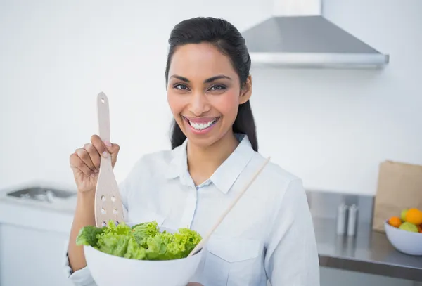 Mooie lachende vrouw tonen salade glimlachen op camera — Stockfoto